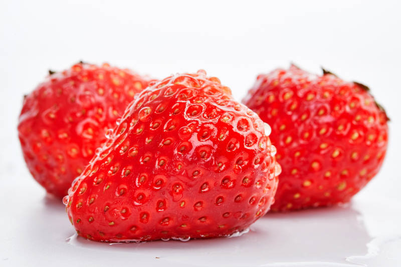 白色背景上摆放的水嫩新鲜草莓图片