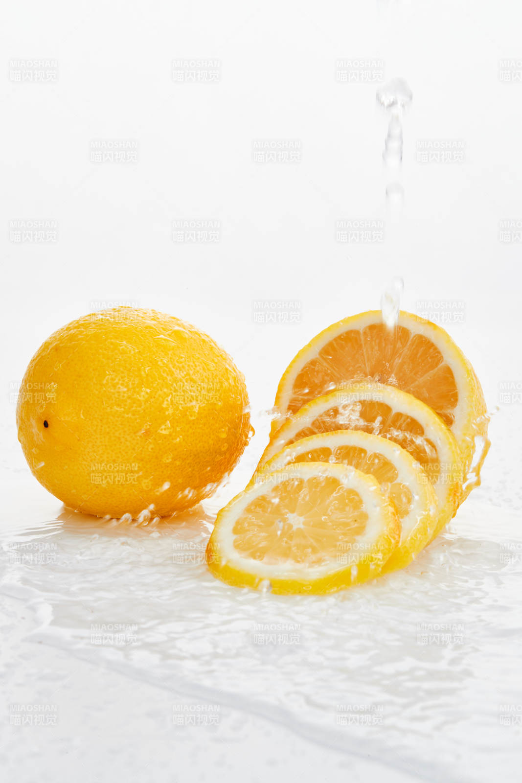 白色背景上摆放的新鲜水嫩柠檬及切片图片
