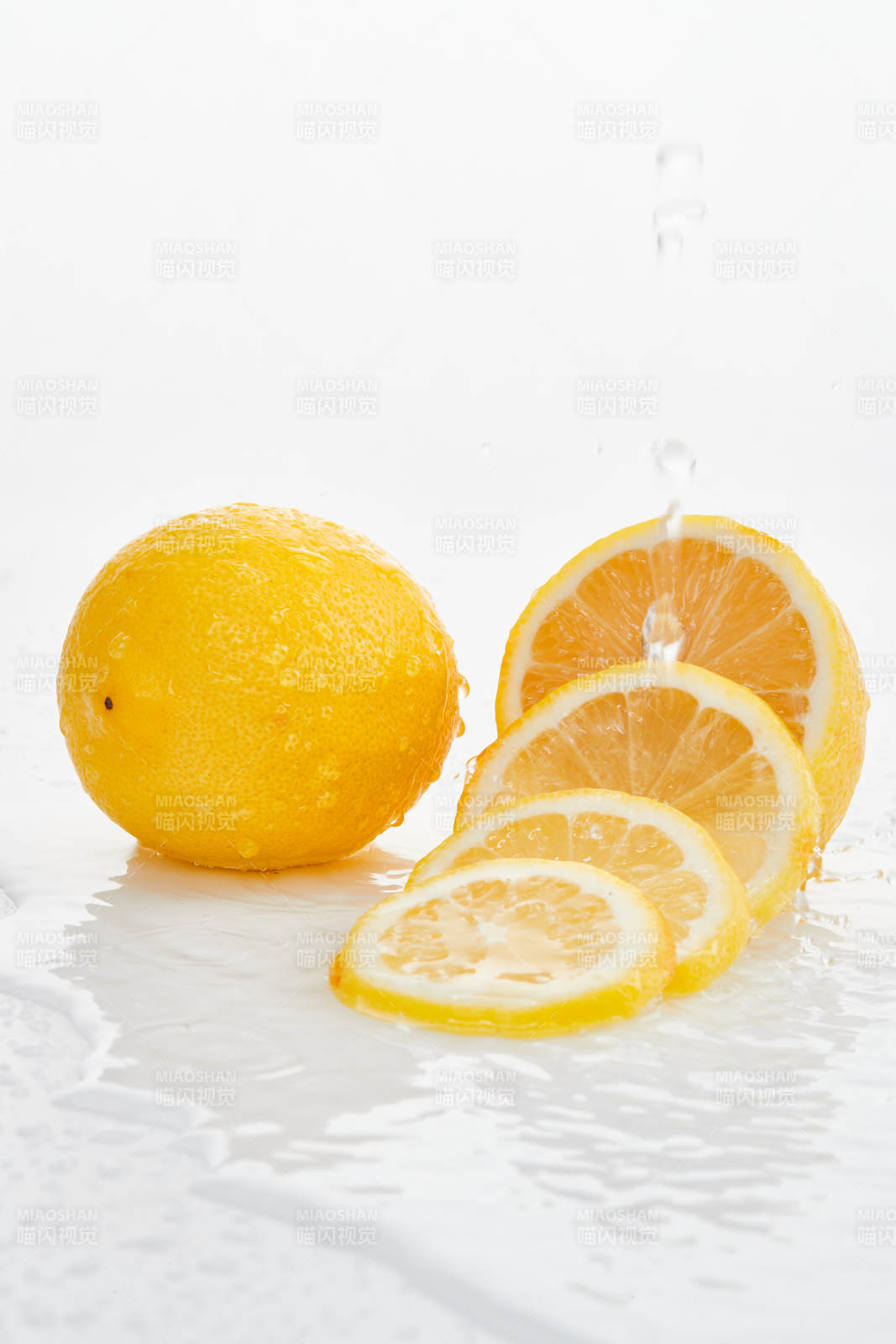 白色背景上摆放的新鲜水嫩柠檬及切片图片