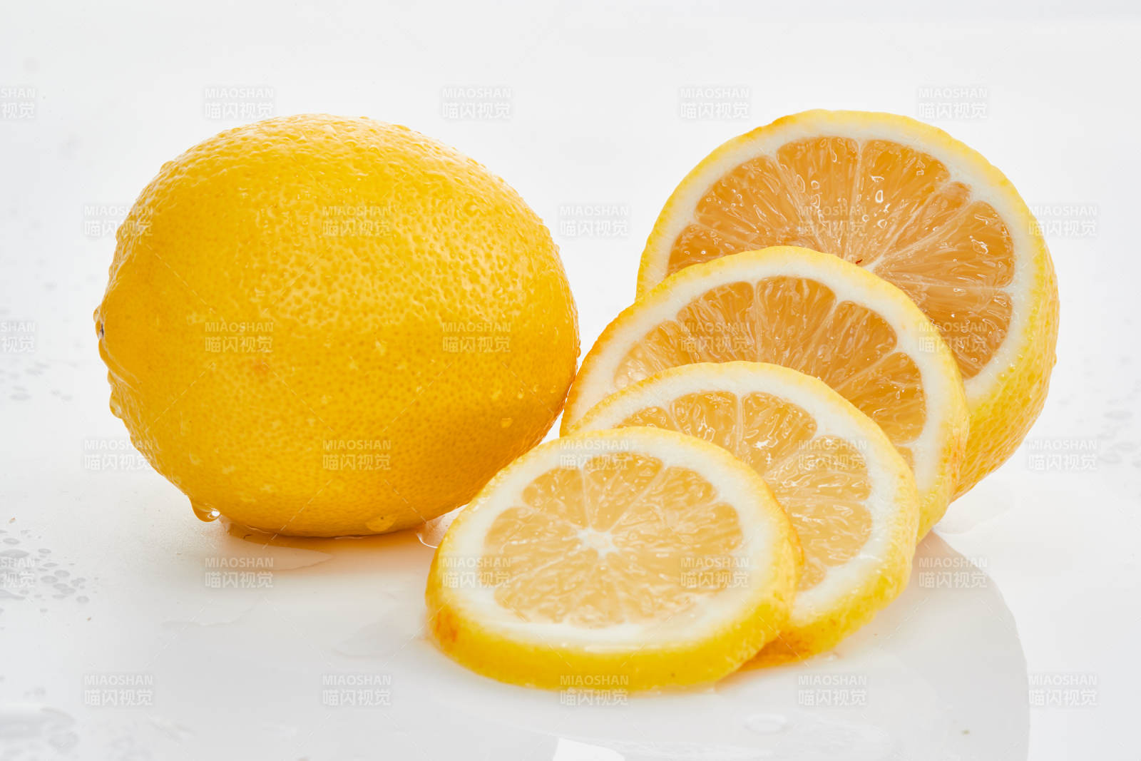 白色背景上摆放的新鲜水嫩柠檬及切片图片