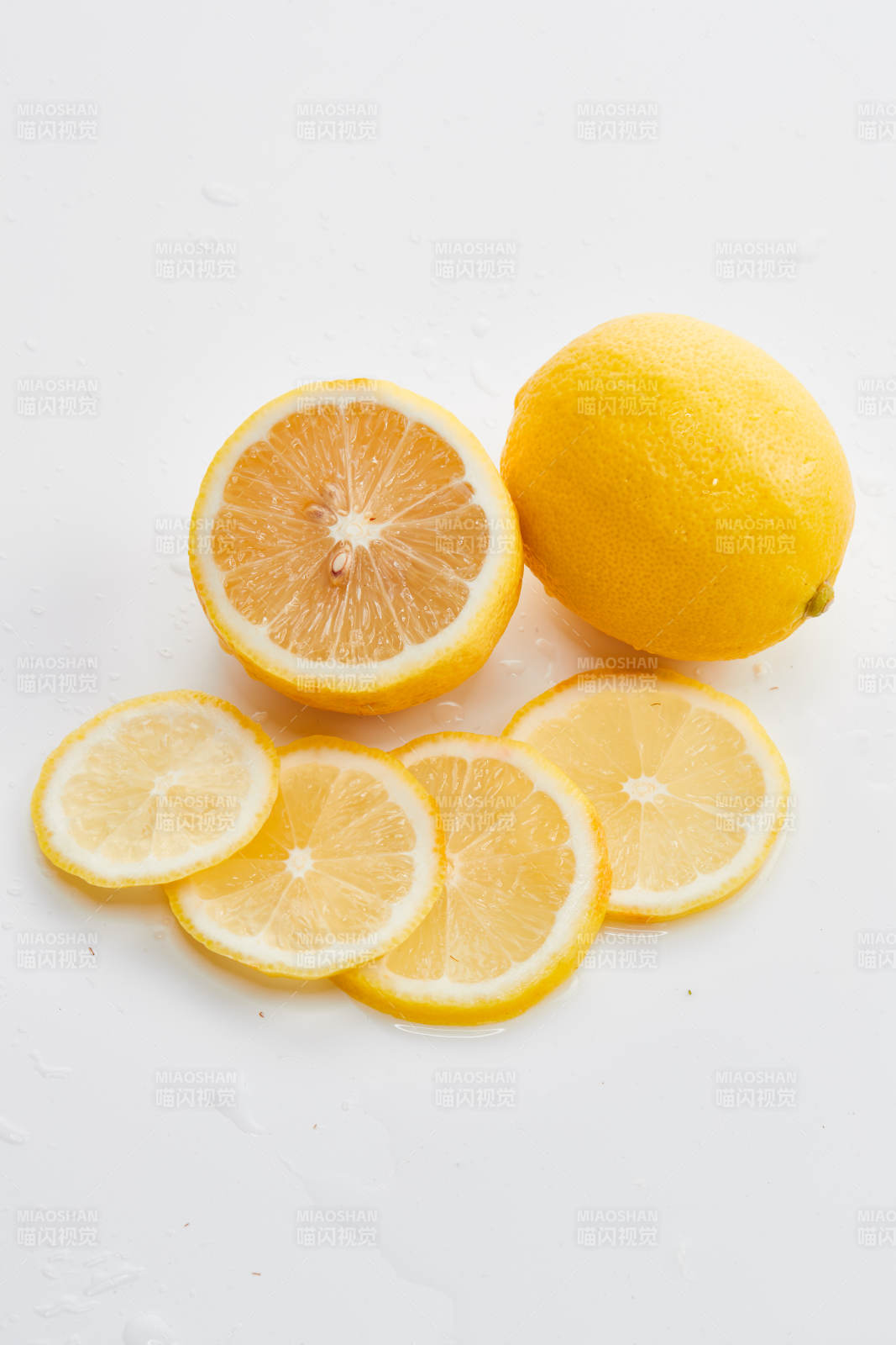 白色背景上摆放的新鲜水嫩柠檬及切片图片