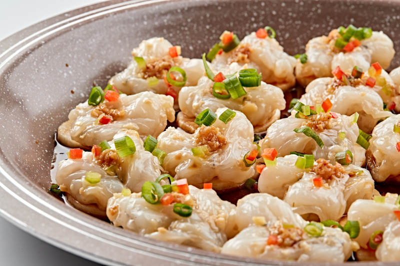 石盘器皿装的葱香油爆大虾仁图片