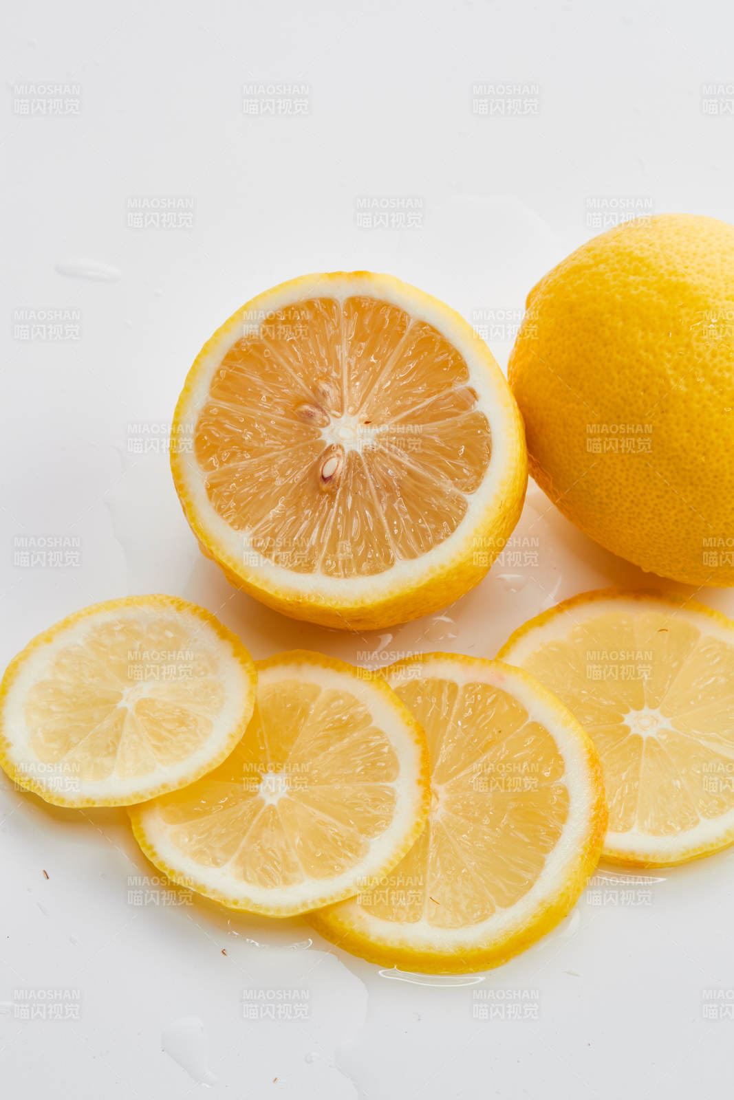 白色背景上摆放的新鲜水嫩柠檬及切片图片