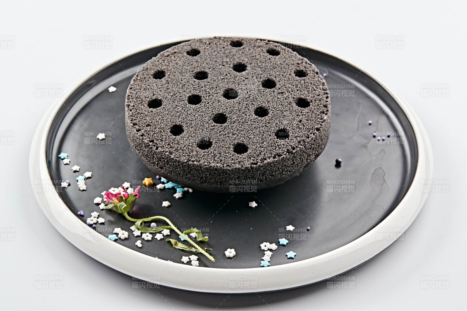 精美餐具装的竹炭粉黑米面蜂窝米糕图片