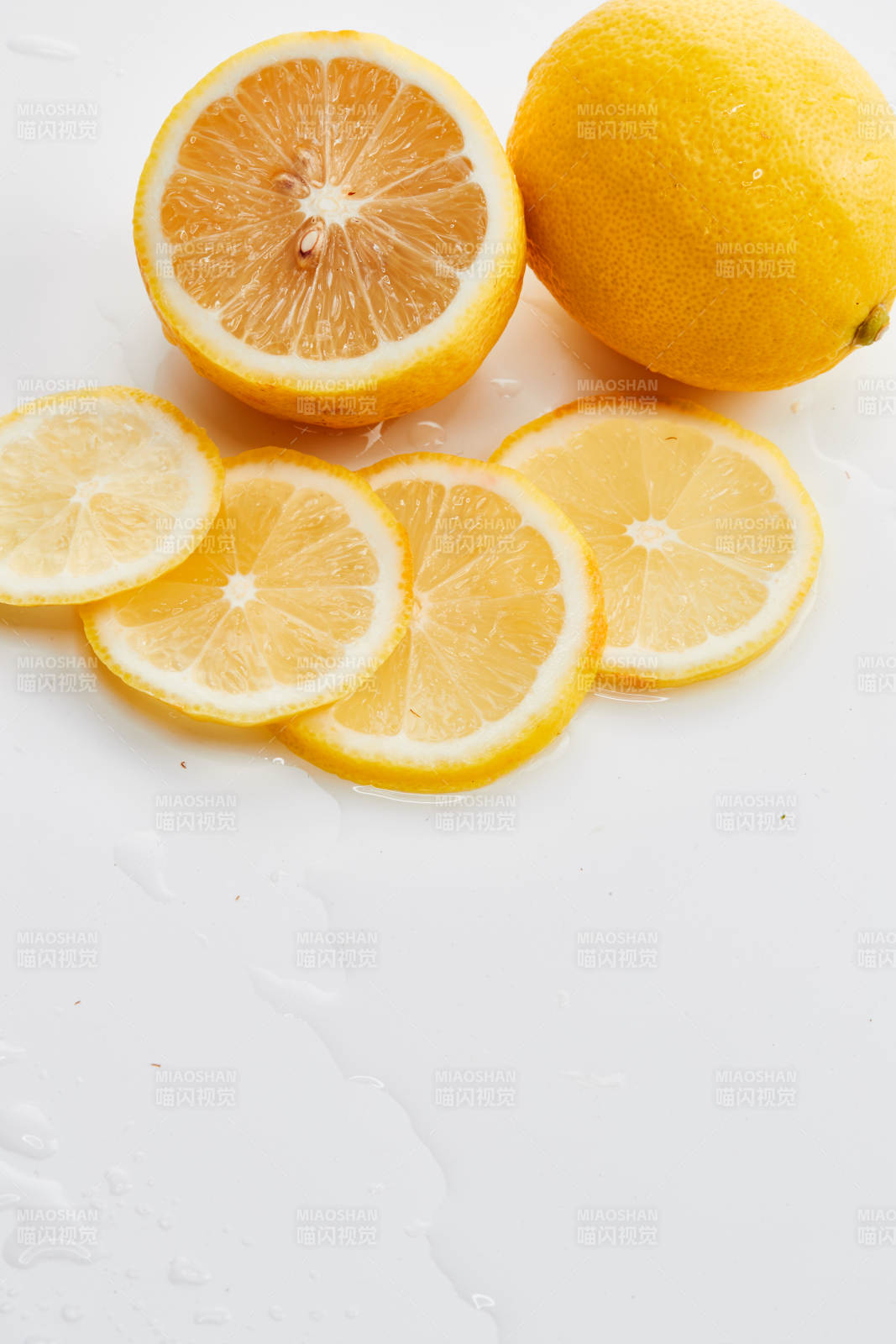 白色背景上摆放的新鲜水嫩柠檬及切片图片