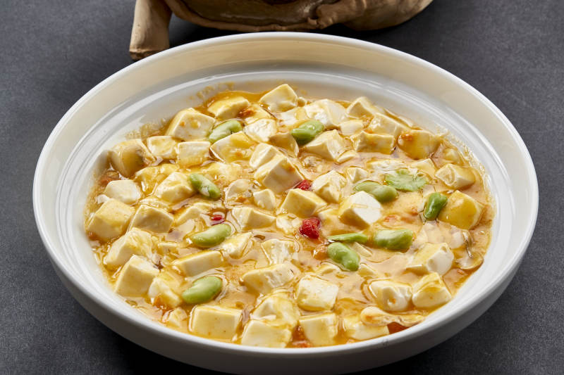 白色圆瓷盘装的蟹黄芸豆焗豆腐图片