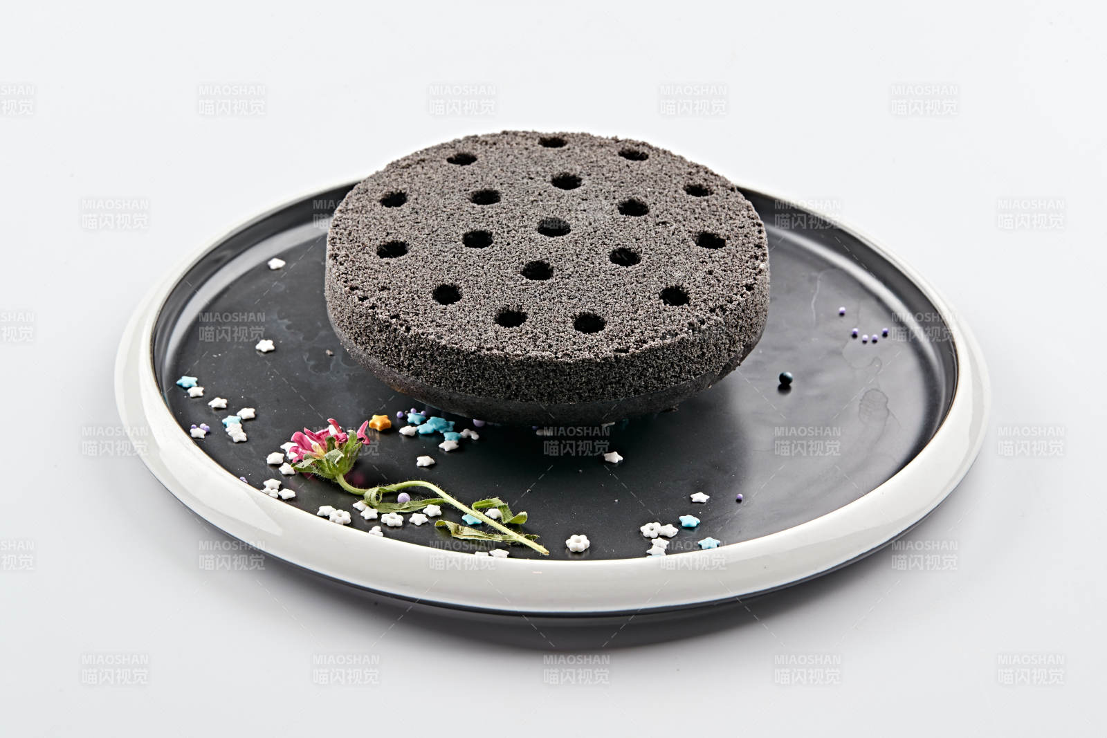 精美餐具装的竹炭粉黑米面蜂窝米糕图片