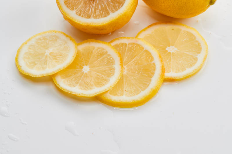 白色背景上摆放的新鲜水嫩柠檬及切片图片