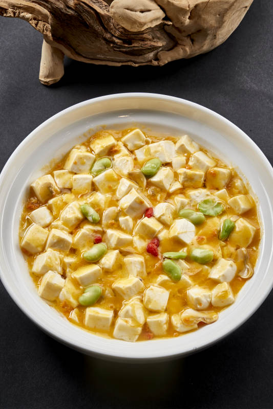 白色圆瓷盘装的蟹黄芸豆焗豆腐图片