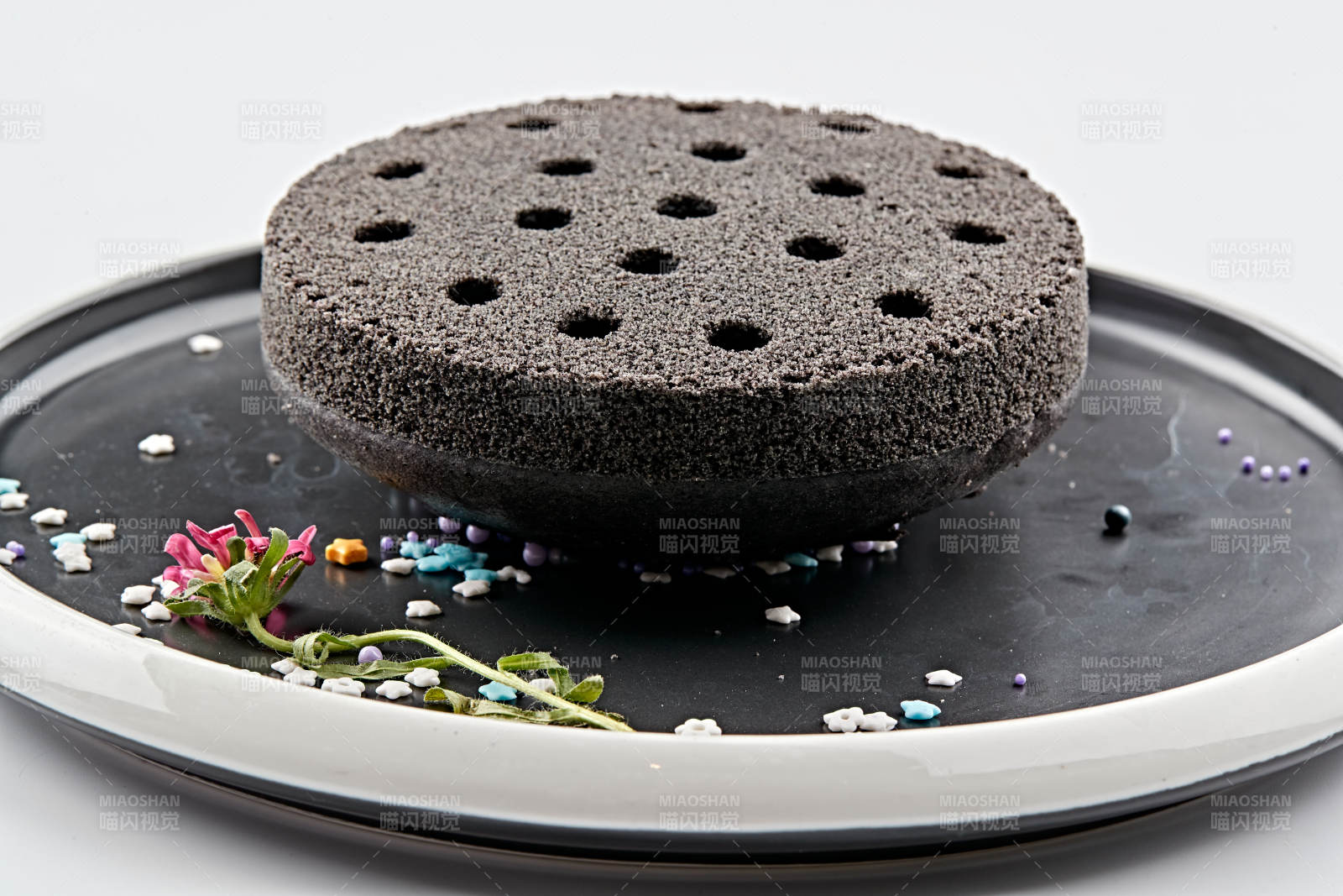 精美餐具装的竹炭粉黑米面蜂窝米糕图片
