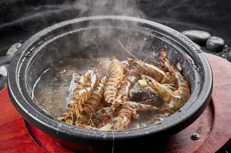 用加热的火山岩石烹煮的新鲜基围虾岩烧图片