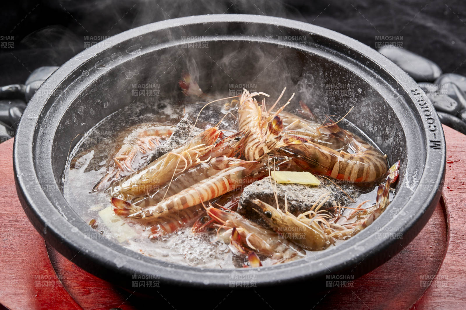 用加热的火山岩石烹煮的新鲜基围虾岩烧图片