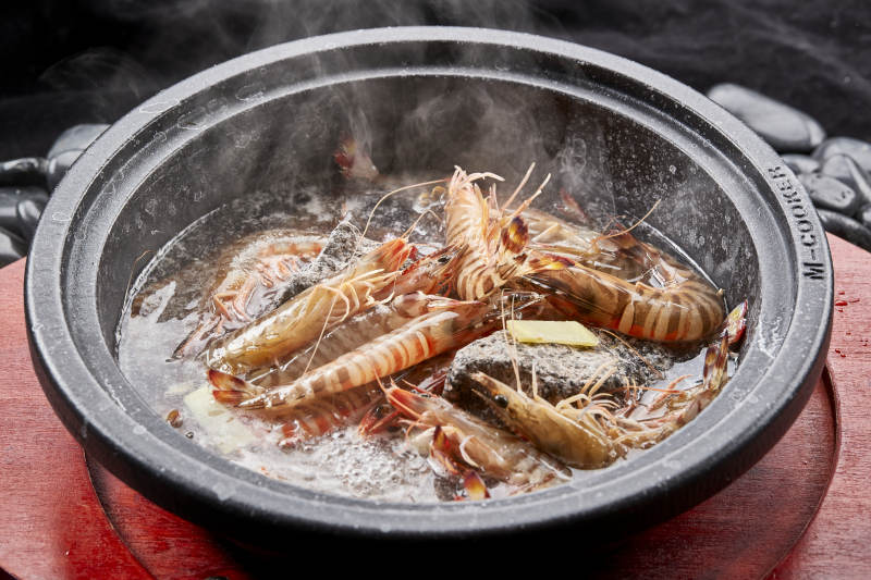 用加热的火山岩石烹煮的新鲜基围虾岩烧图片