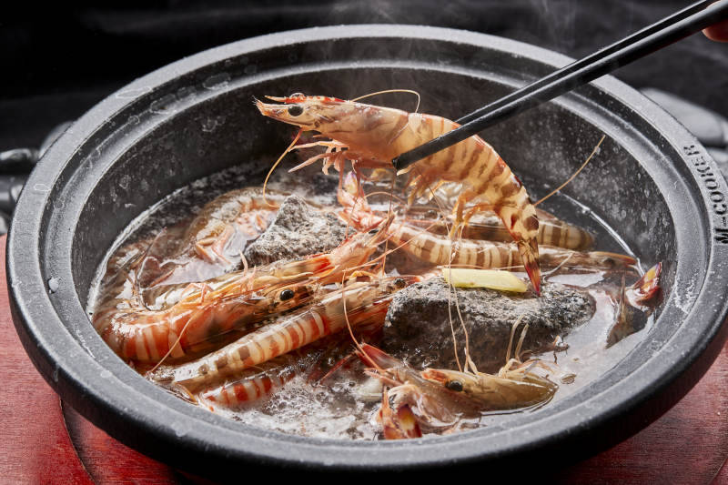 用加热的火山岩石烹煮的新鲜基围虾岩烧图片