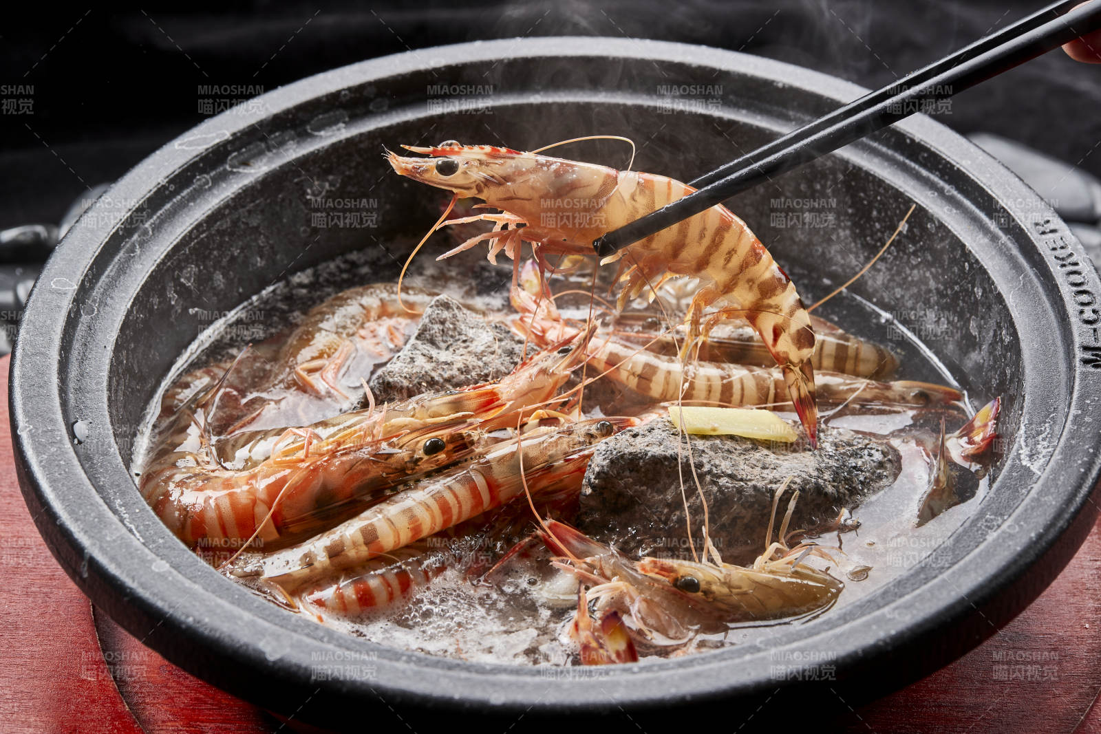 用加热的火山岩石烹煮的新鲜基围虾岩烧图片