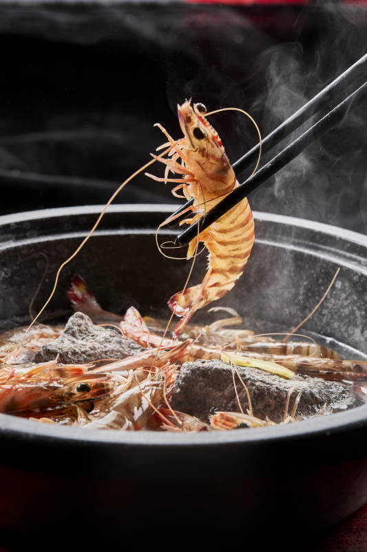 用加热的火山岩石烹煮的新鲜基围虾岩烧图片