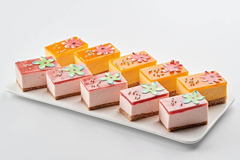 白色瓷盘装的果冻奶油起司蛋糕图片