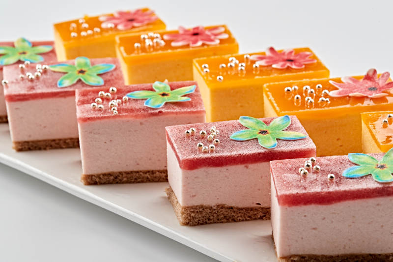 白色瓷盘装的果冻奶油起司蛋糕图片