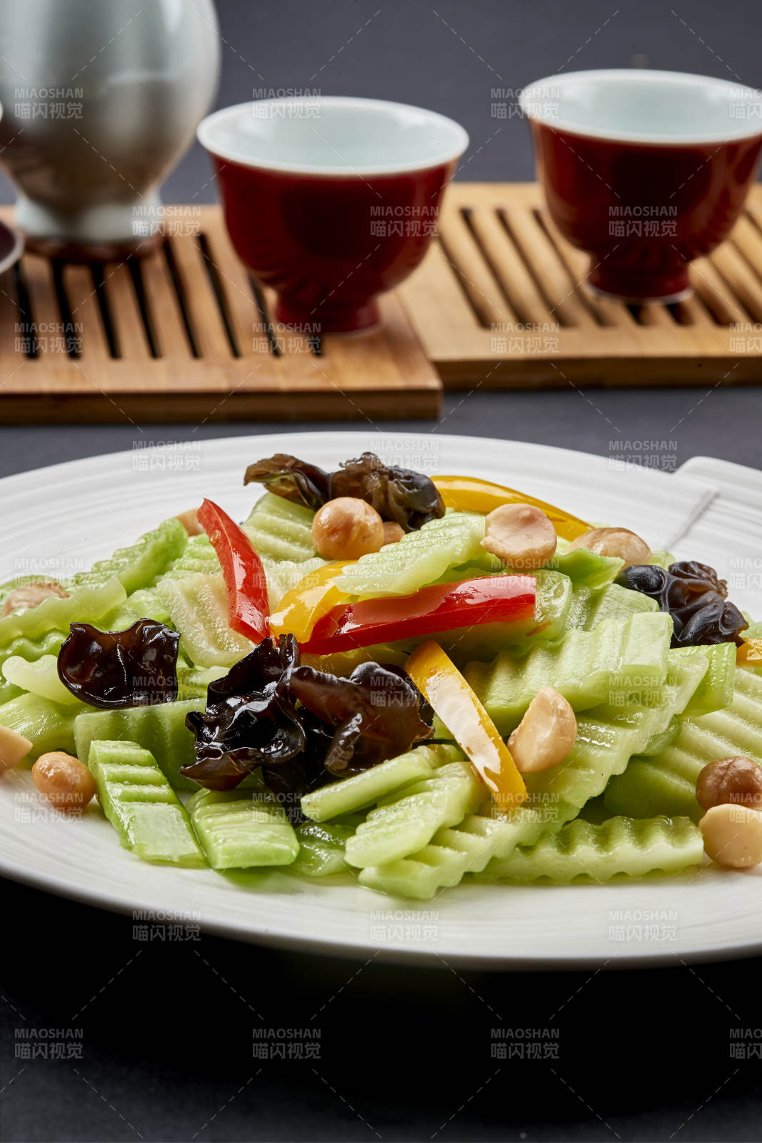 圆瓷盘装的彩椒木耳乳瓜炒银杏图片