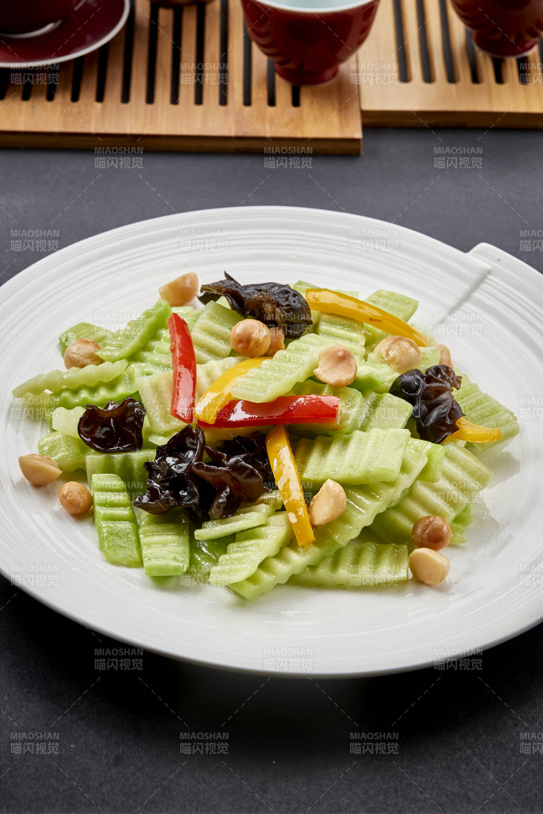 圆瓷盘装的彩椒木耳乳瓜炒银杏图片