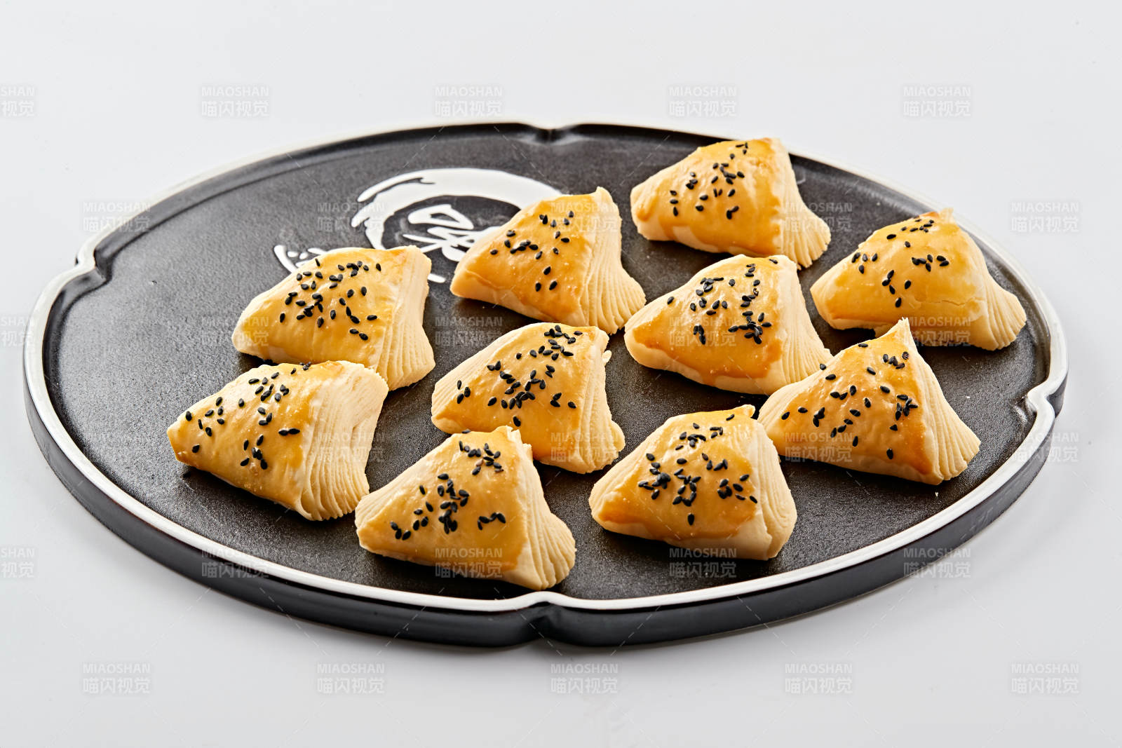 黑色瓷盘装的现场烤制脆皮榴莲酥图片