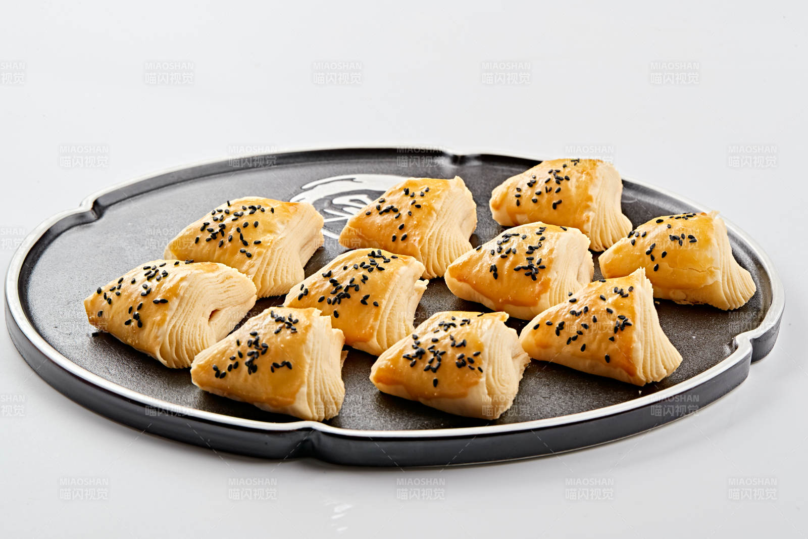 黑色瓷盘装的现场烤制脆皮榴莲酥图片