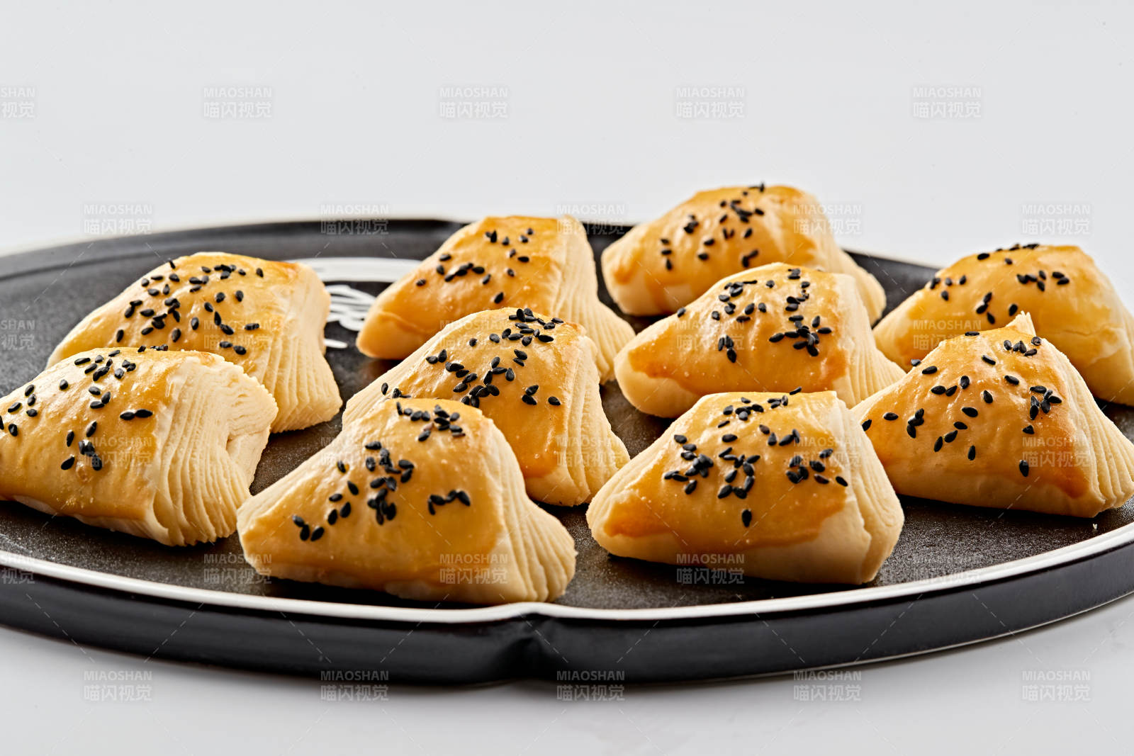 黑色瓷盘装的现场烤制脆皮榴莲酥图片