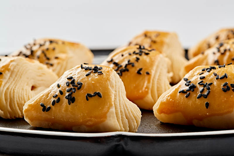 黑色瓷盘装的现场烤制脆皮榴莲酥图片