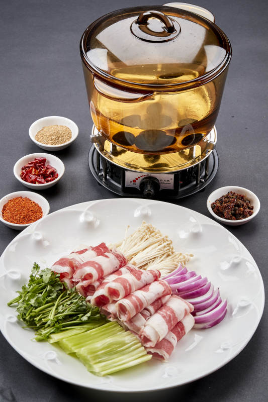 向岩石加热的沸腾食用油中投放鲜美肥牛片图片