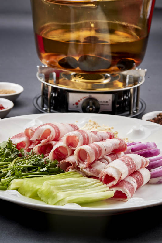 向岩石加热的沸腾食用油中投放鲜美肥牛片图片