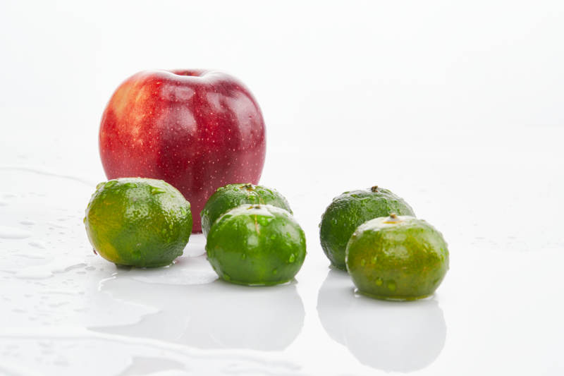 白色背景上摆放的小青柑与富士苹果图片