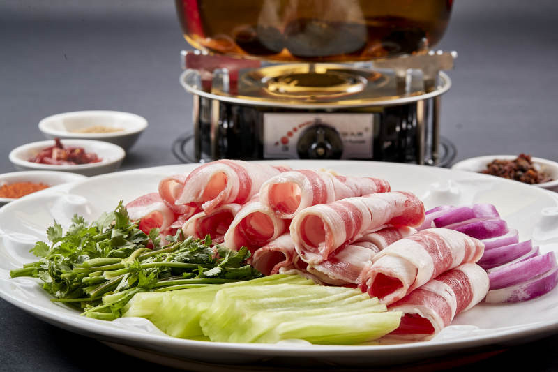 向岩石加热的沸腾食用油中投放鲜美肥牛片图片