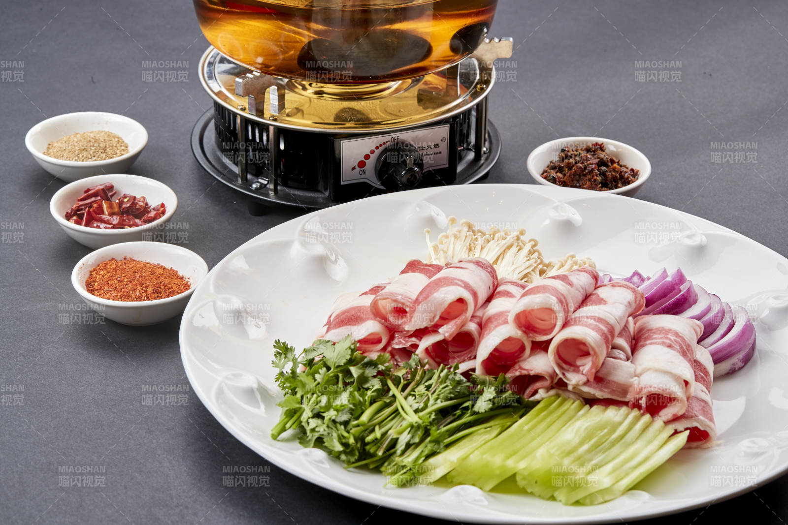 向岩石加热的沸腾食用油中投放鲜美肥牛片图片