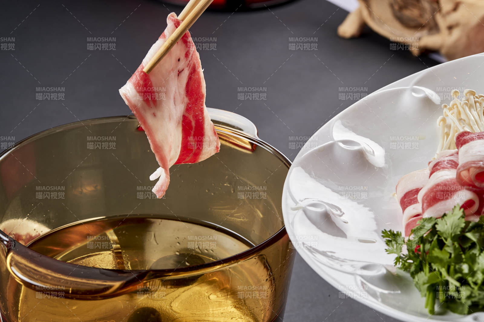 向岩石加热的沸腾食用油中投放鲜美肥牛片图片