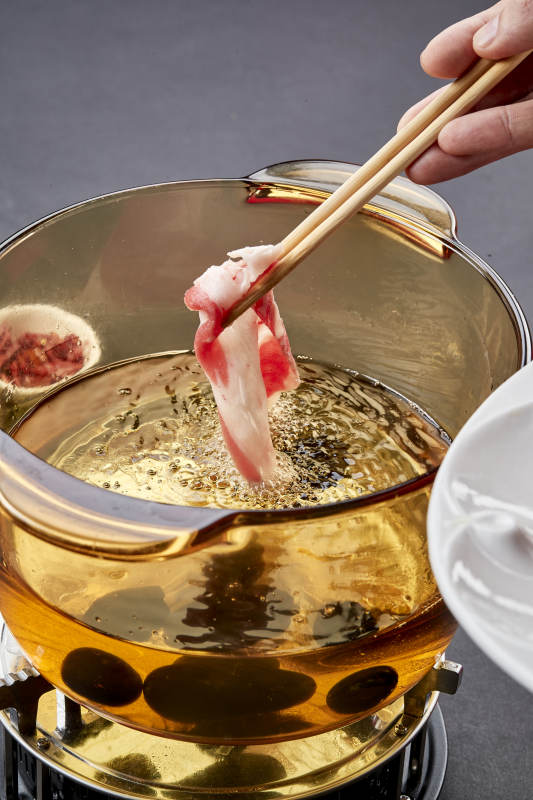 向岩石加热的沸腾食用油中投放鲜美肥牛片图片