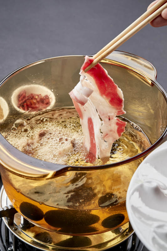 向岩石加热的沸腾食用油中投放鲜美肥牛片图片