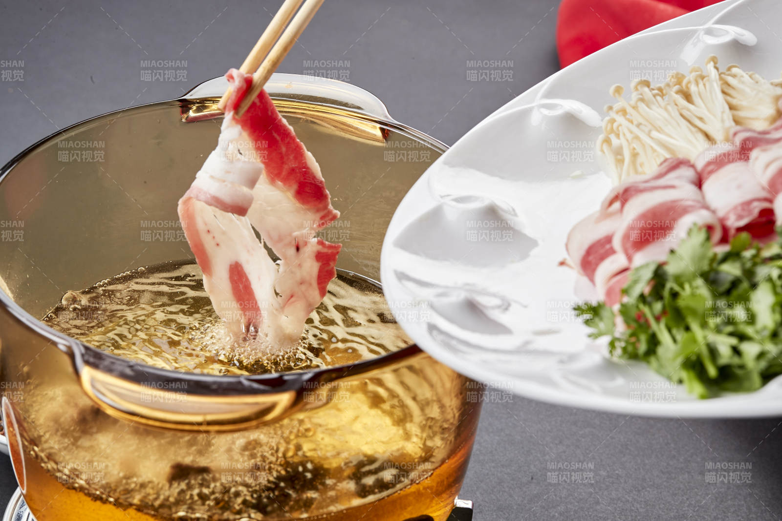 向岩石加热的沸腾食用油中投放鲜美肥牛片图片