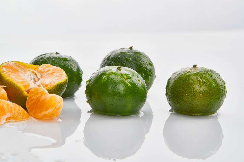 白色背景上摆放的新鲜小青柑图片