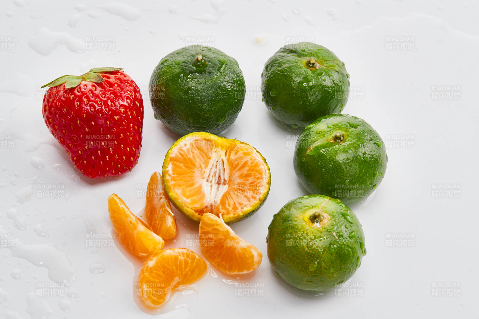 白色背景上摆放的小青柑与草莓图片