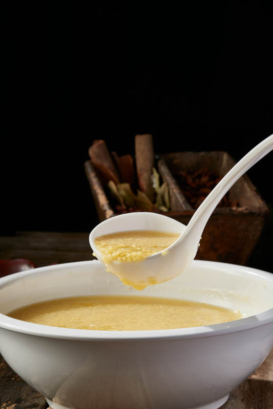 白色瓷盆装的黄金奶汤小米粥图片