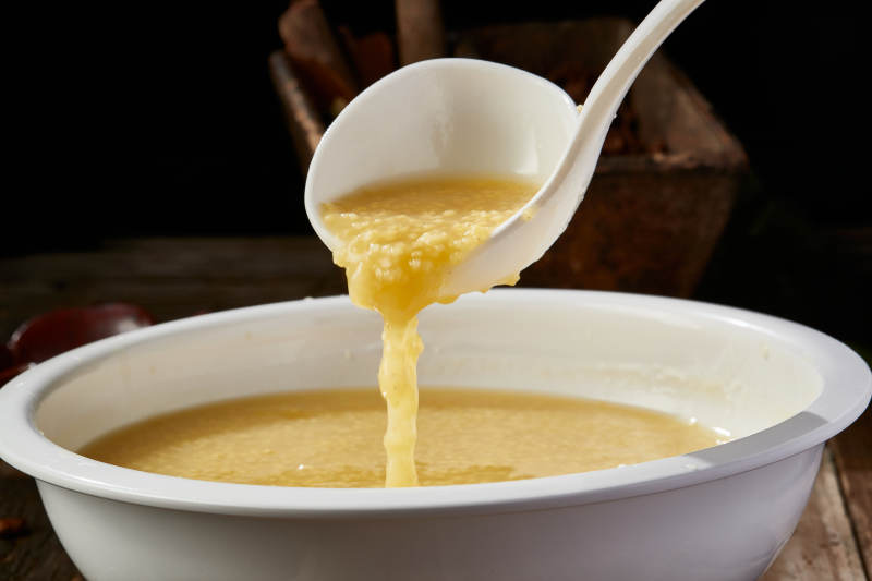 白色瓷盆装的黄金奶汤小米粥图片