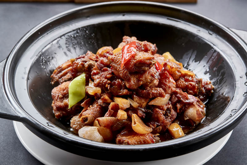 黑色砂锅装的红烧柴鸡煲红焖鸡块图片