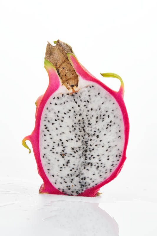 白色背景上摆放切开的新鲜火龙果图片