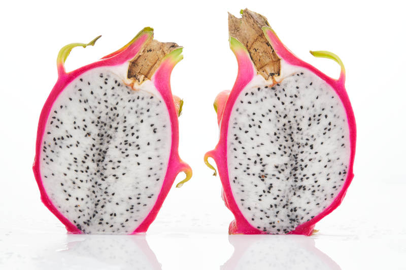 白色背景上摆放切开的新鲜火龙果图片