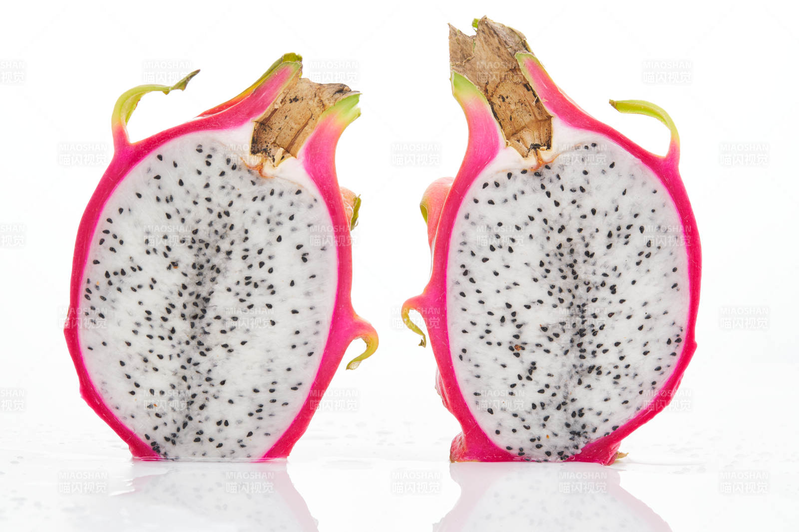 白色背景上摆放切开的新鲜火龙果图片