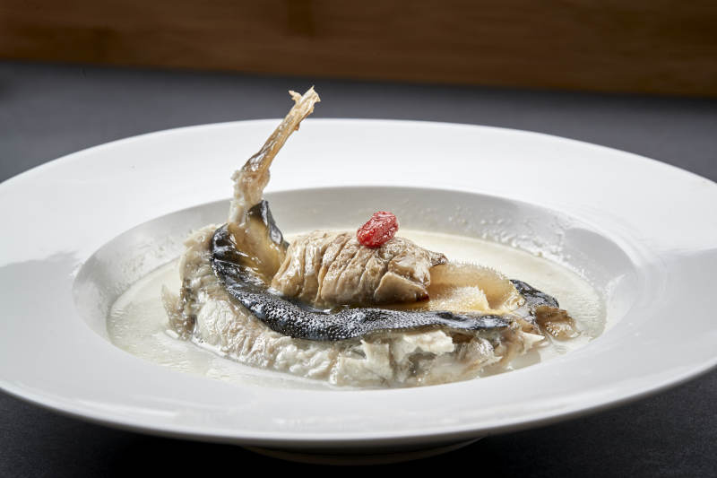 白色圆瓷盘装的时尚位菜奶汤炖小河豚图片