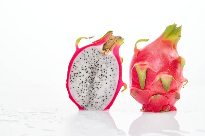 白色背景上摆放切开的新鲜火龙果图片