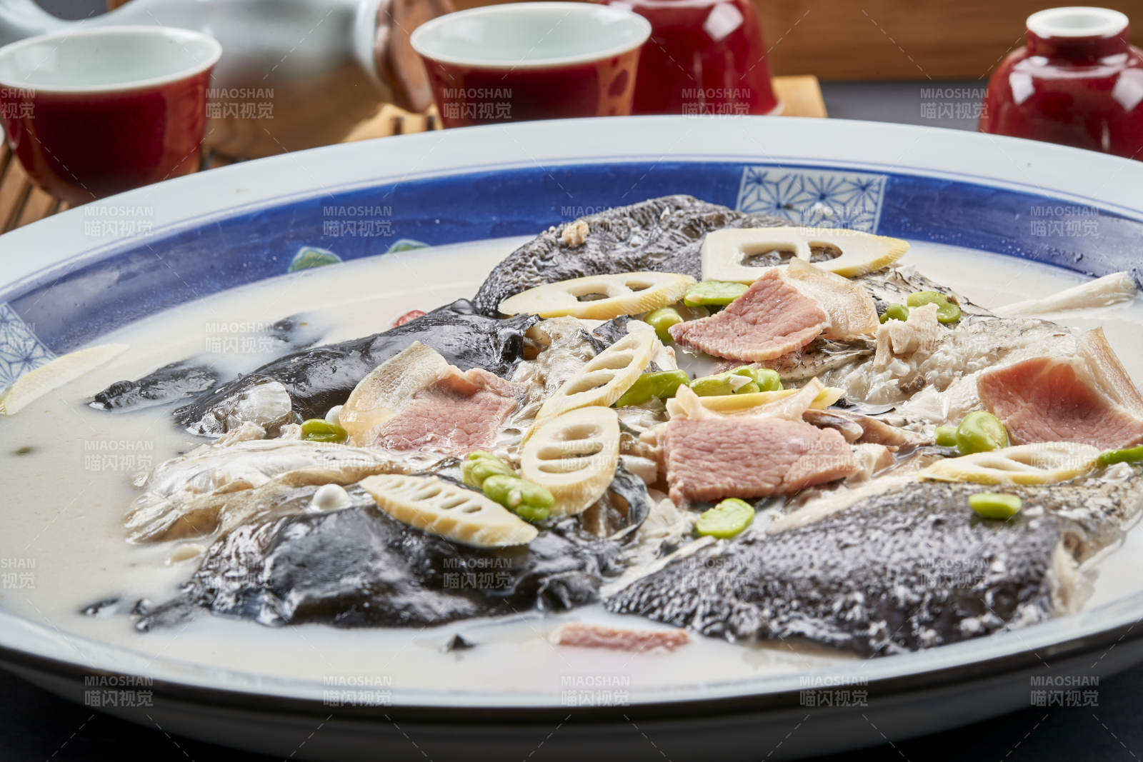 青花瓷盘装的高级奶汤腌笃鲜炖大鲢鱼头图片