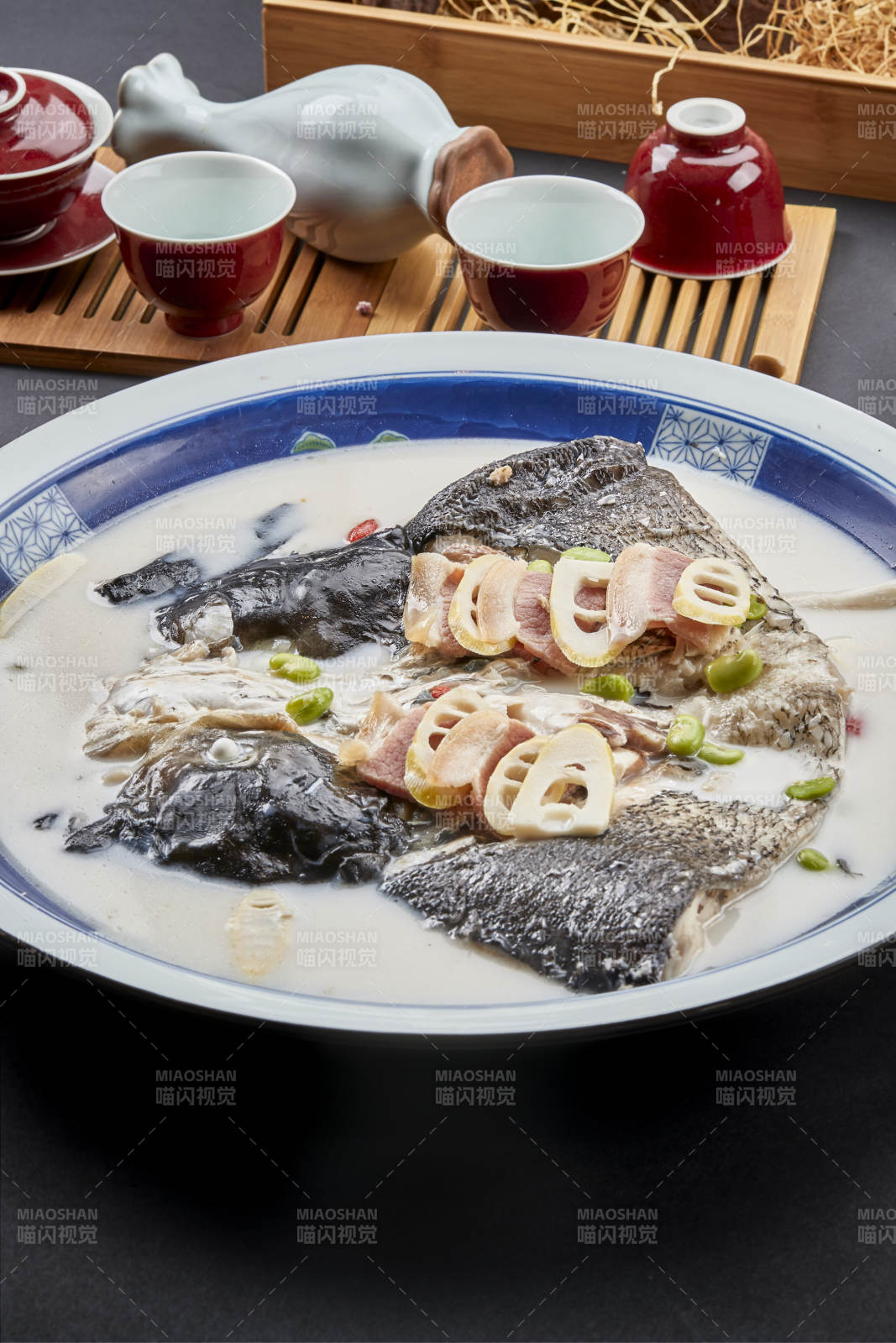 青花瓷盘装的高级奶汤腌笃鲜炖大鲢鱼头图片