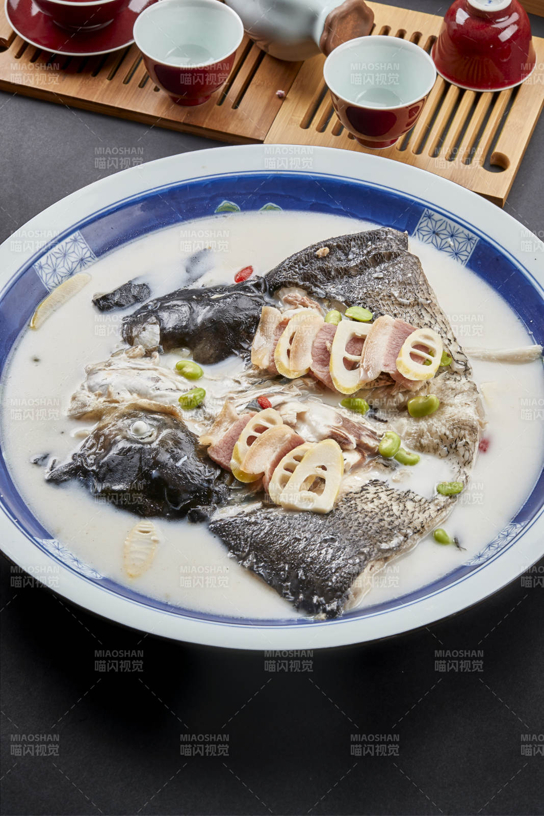 青花瓷盘装的高级奶汤腌笃鲜炖大鲢鱼头图片